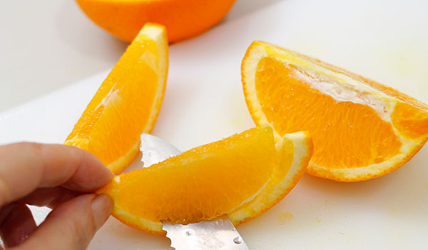 オレンジをペティナイフで切る